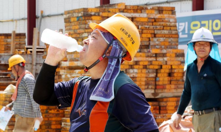 광주 북구 오치동 한 공사 현장에서 작업자들이 더위를 식히기 위해 생수를 마시고 있다. [이미지출처=연합뉴스]