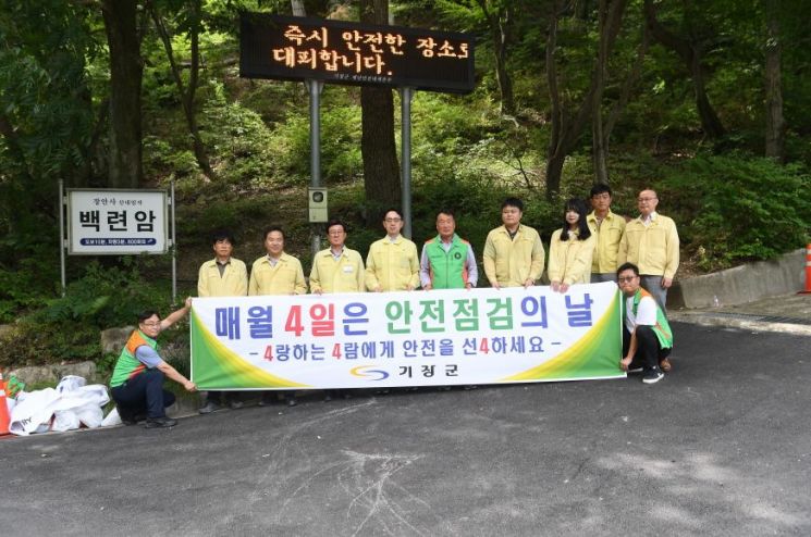 정종복 기장군수(왼쪽에서 세 번째)가 장안사에서 안전문화 확산을 위한 캠폐인을 전개 후 단체 기념사진을 찍고 있다.