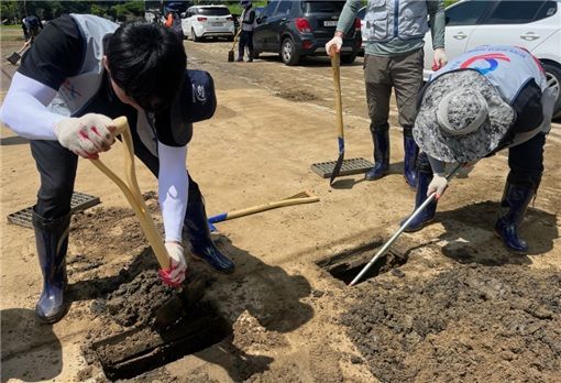 지난달 27일 한국도로공사 대구경북본부 직원들이 예천군 동본교 일대를 방문해 하천 범람으로 인한 강변 토사물을 제거하고 있다. / 사진제공=한국도로공사