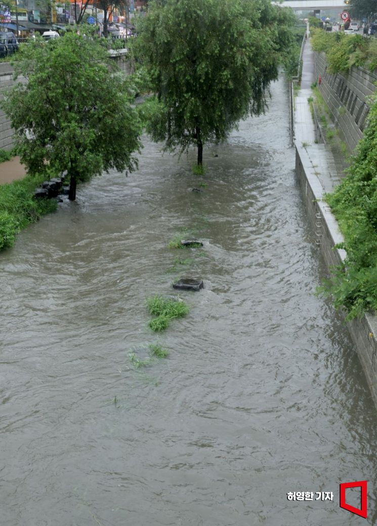 Due to the impact of Typhoon Khanun, heavy rain is falling, causing the water level of Cheonggyecheon Stream in Seoul to rise, submerging part of the walkway. Photo by Heo Younghan younghan@