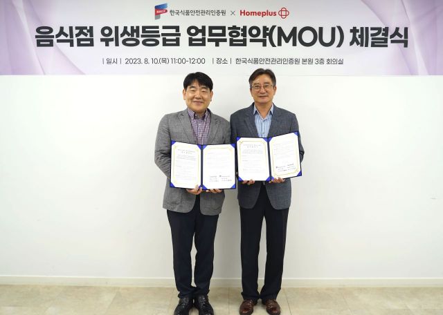 송명헌 홈플러스 안전보건관리부문장(왼쪽)과 홍진환 한국식품안전관리인증원 이사(오른쪽)가 지난 10일 충청북도 청주시 한국식품안전관리인증원 본원에서 업무협약 체결 후 기념 사진을 촬영하고 있다. [사진제공=홈플러스]