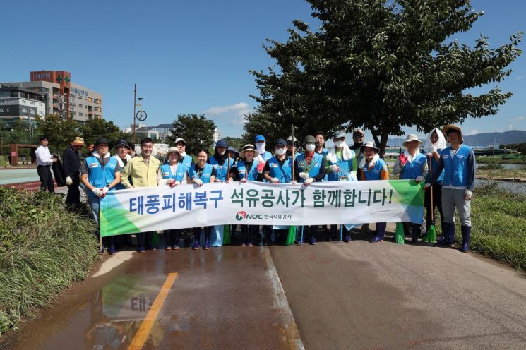 석유공사 임직원들이 11일 울산 태화강 둔치에서 태풍 카눈 피해 복구 작업을 벌인 뒤 카메라 앞에 섰다.