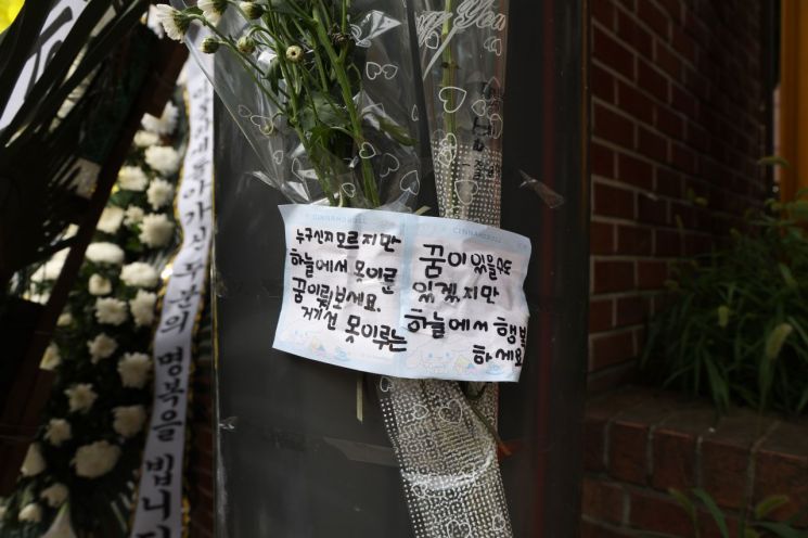 9일 경기도 의정부시의 한 초등학교에서 추모객이 남긴 메시지가 꽃과 함께 붙어 있다. [사진출처=연합뉴스]
