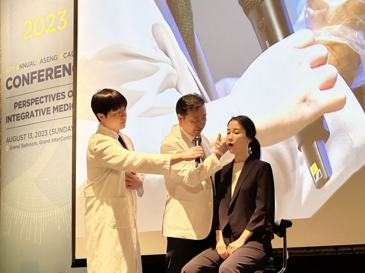 자생한방병원 설립자 신준식 박사(가운데)가 2023 자생국제학술대회 기조 강연을 통해 턱관절 장애 한의 치료법을 직접 시연하고 있다. [사진제공=자생한방병원]