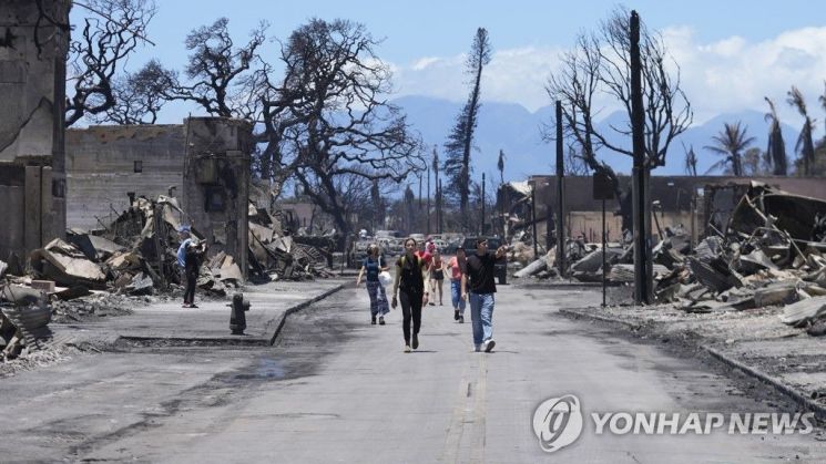 화재 피해지역인 하와이 마우이섬 라하이나 지역을 둘러보는 주민들. [이미지출처=연합뉴스]