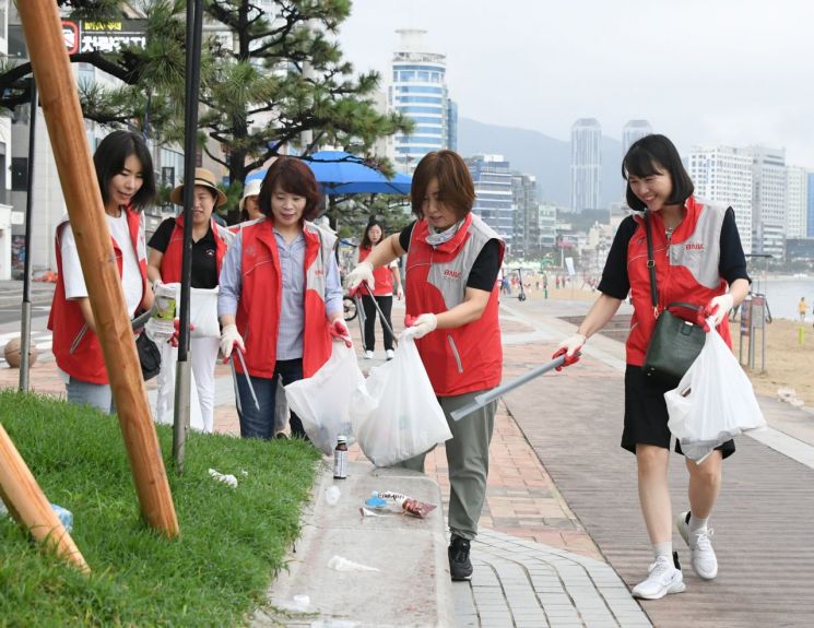 BNK부산은행 임직원들이 19일 오전 부산 광안리해변에서 환경정화 봉사활동을 벌이고 있다.