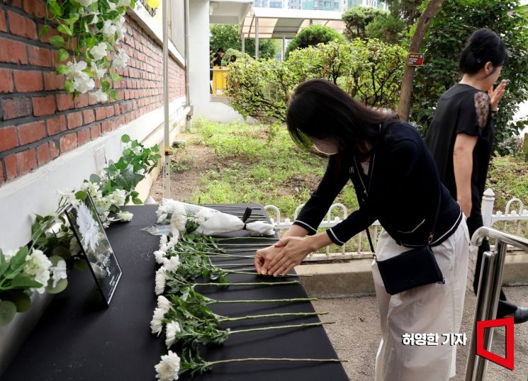 숨진 서이초등학교 교사의 49재일인 지난 9월4일 서울 서이초등학교에 마련된 헌화대에 한 시민이 꽃을 놓고 있다. 사진=허영한 기자 younghan@