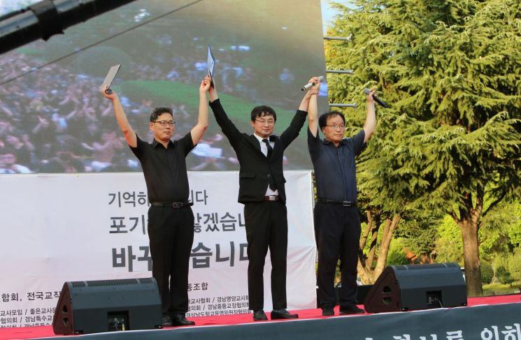 노경석 전교조 경남지부장(가장 왼쪽부터), 김광섭 경남교총 회장, 이충수 경남교사노조 위원장이 연대 발언 후 인사하고 있다. [사진=이세령 기자]