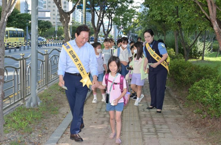 박완수 경남도지사가 아이와 함께 학교로 걸어가고 있다. [사진제공=경남도청]