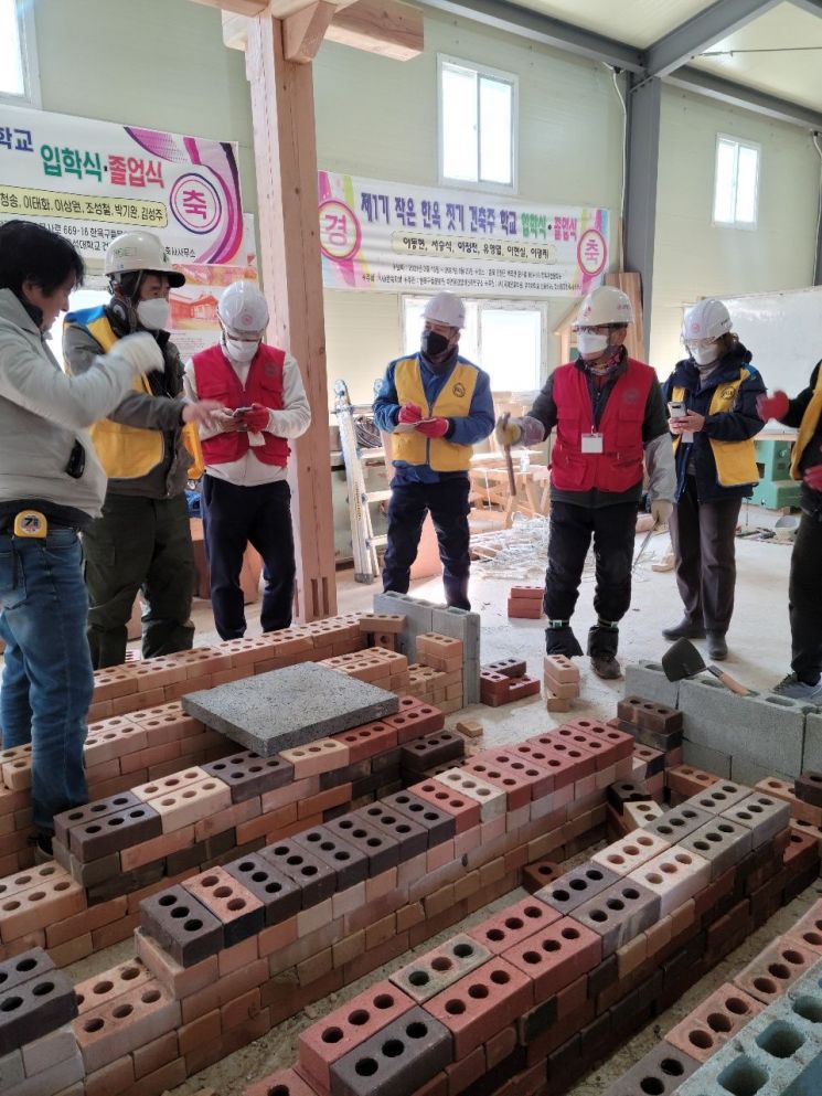 국제온돌학회 김준봉 회장이 벽돌을 이용하여 온돌을 실제 만들어 보고 온돌의 원리와 구조를 설명하고 있다.［사진제공=보성군］