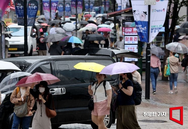 13일 중부지방에 가을 비가 내린 가운데 서울 명동에서 관광객들과 시민들이 우산을 들고 길을 가고 있다. 사진=허영한 기자 younghan@