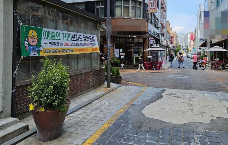 20돌을 맞은 추억의 충장축제를 앞두고 광주 동구 예술의 거리 도로가 파손돼 정비공사를 한다는 안내 현수막이 붙어 있다.[사진제공=광주광역시 동구]