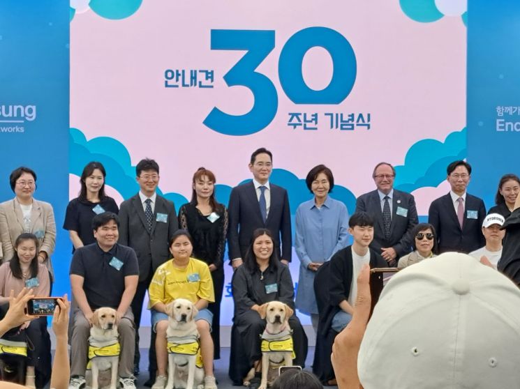 두 번째 줄 왼쪽 다섯번 째부터 이재용 삼성전자 회장과 홍라희 여사가 삼성화재 안내견학교 30주년 기념식에서 참석자, 안내견들과 기념사진을 촬영하고 있다. / [사진=김평화 기자]