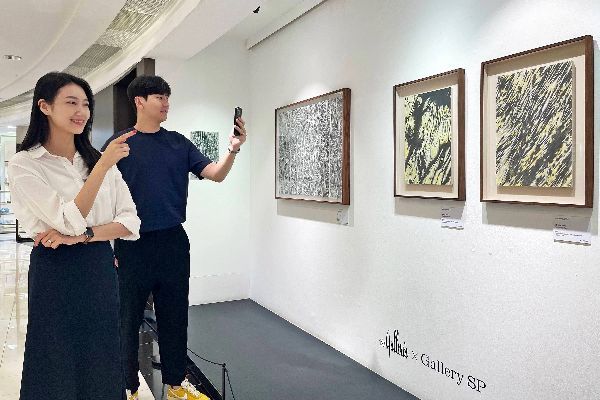 고객들이 갤러리아백화점 서울 명품관에서 진행하는 한진 작가 전시회에서 작품을 관람하고 있다. [사진제공=갤러리아백화점]