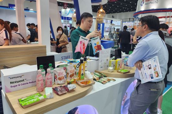 A Samyang Corporation representative is consulting with visitors at the promotional booth of Fi-Asia Thailand, the largest food ingredient exhibition in Southeast Asia, held in Bangkok, Thailand. <br>[Photo by Samyang Corporation]