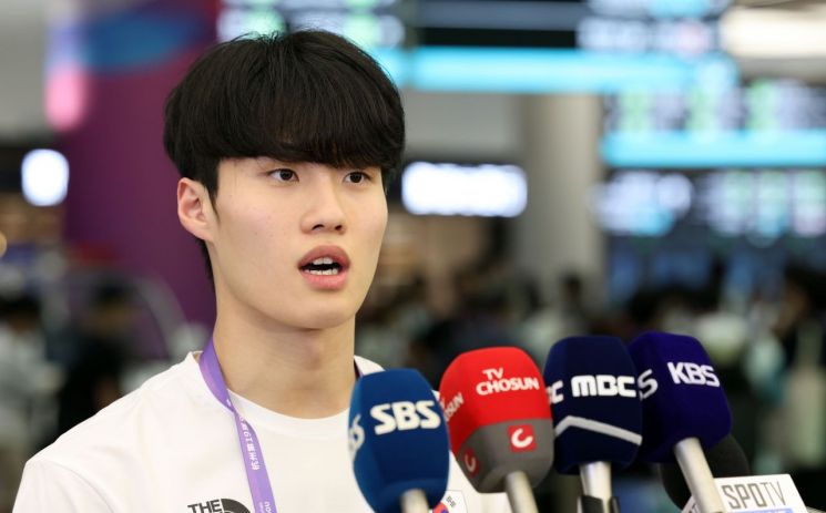 수영대표팀의 황선우가 지난 21일 중국 항저우 샤오산 국제공항을 통해 입국하며 취재진 질문에 답하고 있다.   [사진 제공= 연합뉴스]