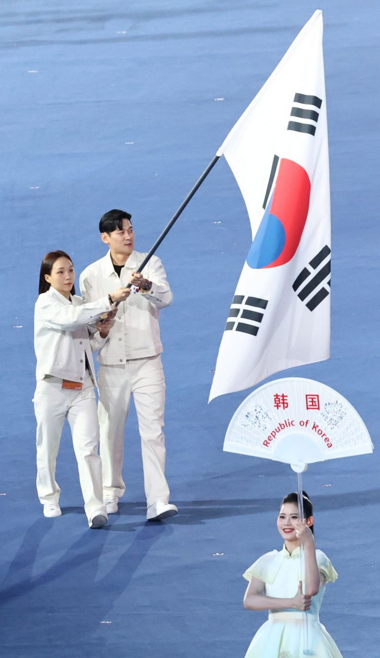 펜싱 구본길(오른쪽)과 수영 김서영이 지난 23일 중국 항저우 올림픽 스포츠센터 스타디움에서 열린 2022 항저우 아시안게임 개회식에서 기수를 맡아 입장하고 있다. 25일 경기에서 구본길은 펜싱 사브르 남자 개인전 아시안게임 4연패, 김서영은 개인혼영 200m에서 2연패를 노린다.  [사진 제공= 연합뉴스]