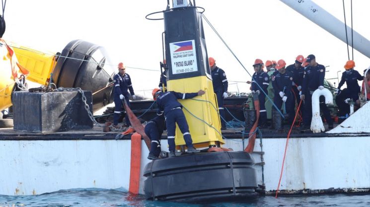 지난 5월 필리핀 해안 경비대가 남중국해서 국기가 달린 부표를 설치하는 모습 [이미지출처=연합뉴스]