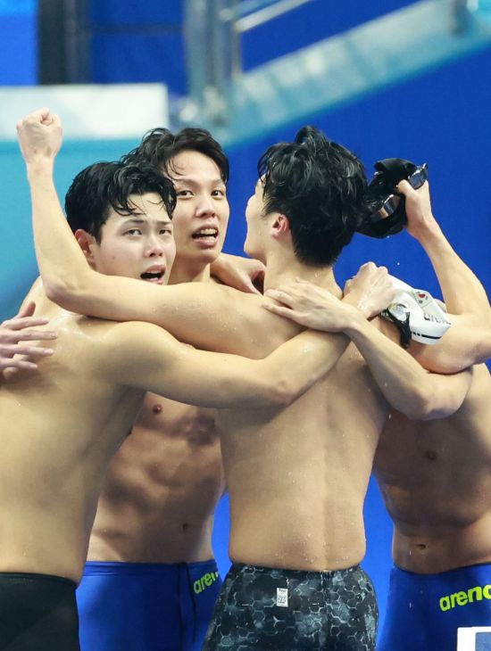 양재훈, 이호준, 김우민, 황선우가 25일 중국 항저우 올림픽 스포츠센터 수영장에서 열린 2022 항저우 아시안게임 수영 남자 계영 800m에서 금메달을 확정한 뒤 서로 얼싸안고 기뻐하고 있다.    [사진 제공= 연합뉴스]