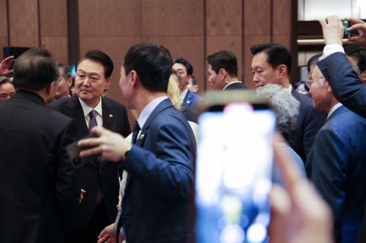 윤석열 대통령이 5일 서울 송파구 잠실 롯데호텔 월드에서 열린 2023 세계한인회장대회 및 제17회 세계한인의 날 기념식에서 참석자들과 악수 및 기념 촬영을 하며 퇴장하고 있다. [이미지출처=연합뉴스]