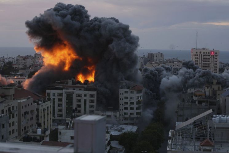 7일(현지시간) 팔레스타인 가자지구 중심도시인 가자시티 도심의 건물이 이스라엘군의 공습으로 화염에 휩싸여있다.[이미지출처=AP·연합뉴스]