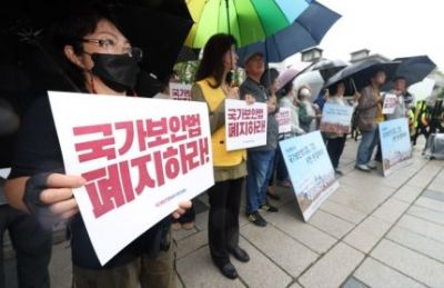 지난달 26일 오후 서울 종로구 헌법재판소 앞에서 손팻말을 들고 있는 국가보안법폐지국민행동 참가자들 [이미지출처=연합뉴스]