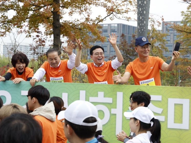 진교훈 서울 강서구청장(정면 왼쪽 세 번째)이 14일 2023 허준마라톤 대회에서 두 손을 번쩍 들어 참가자들의 안전한 완주를 응원하고 있다.