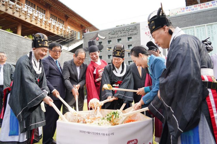 이필형 동대문구청장(왼쪽 다섯 번째)과 행사에 참석한 내빈들이 ‘한방산채비빔밥 나눔 행사’에서 비빔 퍼포먼스를 하고 있다.