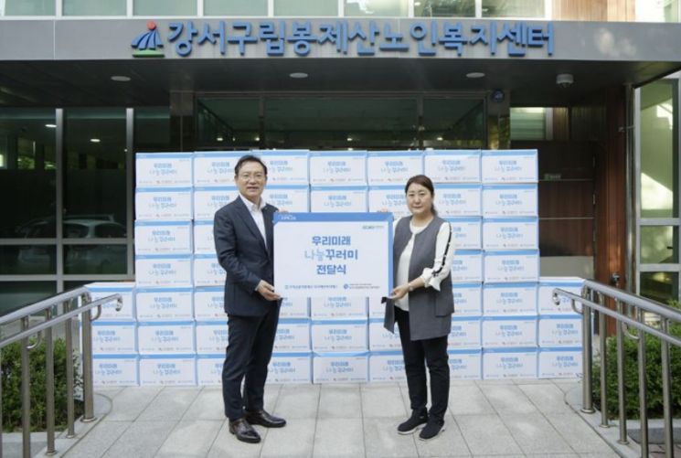 고정현 우리에프아이에스대표(왼쪽)가 강서구 사회복지시설에기증품을 전달하고 있다. [사진제공=우리에프아이에스]