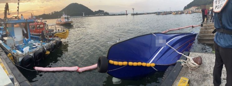 충돌사고 여파로 침수된 낚시어선 주변에 오일펜스가 설치돼 있다. [사진제공=창원해양경찰서]