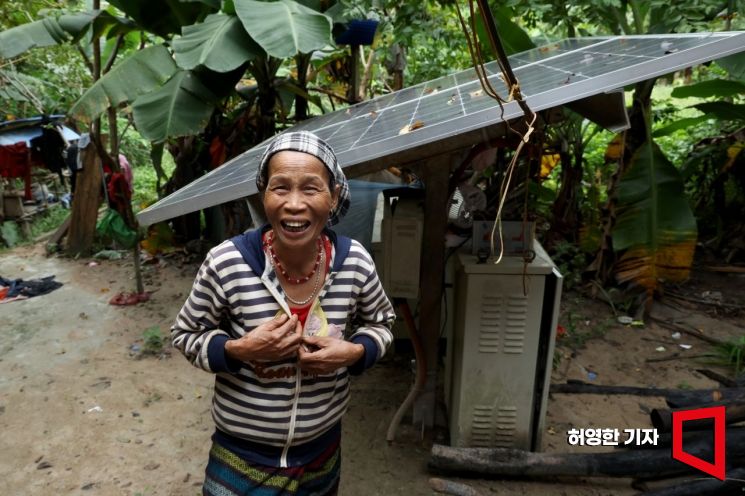 越南广平省Ban Lao Khon村居民Ho Thi Dam在自家后院安装的太阳能发电机前交谈时开心大笑。照片=记者Heo Younghan提供