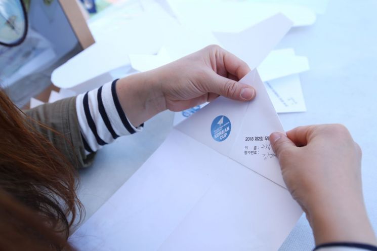 무림페이퍼가 주최한 종이비행기대회 참가자가 종이비행기를 접고 있다. [사진제공=무림페이퍼]