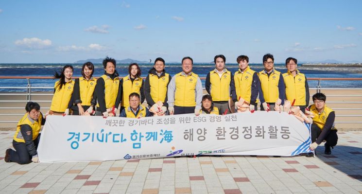 시석중 경기신용보증재단 이사장이 지난 20일 경기신보 임직원들과 안산 대부도 방아머리 해수욕장 일대의 해양쓰레기를 수거한 뒤 기념사진을 찍고 있다.