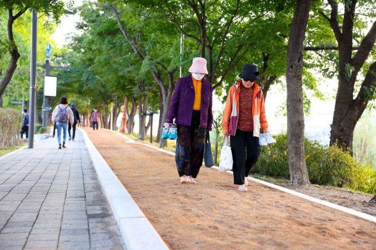 구로구가 안양천에 조성한 황톳길을 시민들이 맨발로 걷고 있다. [사진제공=구로구]