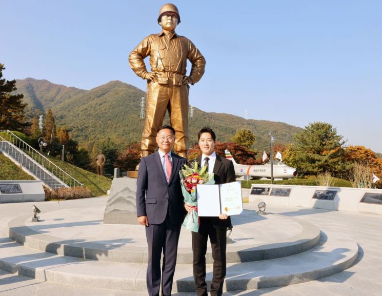 김재욱 칠곡군수가 백선엽 장군 동상앞에서 최영재 씨(오른쪽)에게 홍보대사 위촉장을 전달한 뒤 기념촬영을 하고 있다.