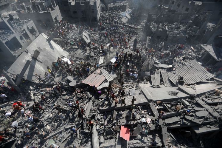 26일(현지시간) 가자지구 칸 유니스에서 주민들이 건물 잔해를 헤치며 생존자 수색 작업을 벌이고 있다. [이미지출처=신화연합뉴스]
