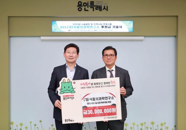 이경률 서울의과학연구소 총괄의료원장(오른쪽)이 이상일 용인시자원봉사센터 이사장(용인시장)에게 후원금을 전달하고 있다. [사진제공=용인시]