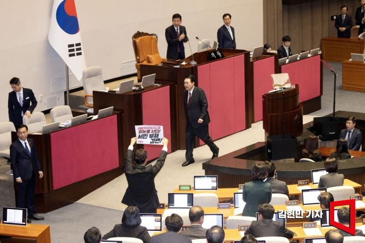 강성희 진보당 의원이 31일 국회 본회의장에서 시정연설을 마치고 퇴장하는 윤석열 대통령을 향해 손팻말을 들어 보이고 있다. 사진=김현민 기자 kimhyun81@