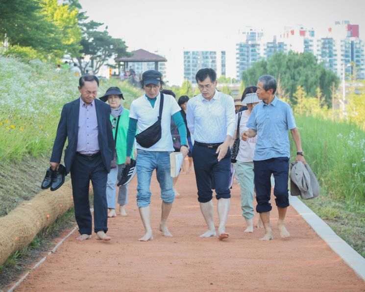 이기재 양천구청장(오른쪽 두번째)이 시민들과 함께 안양천 황톳길을 맨발로 걷고 있다. [사진제공=양천구]