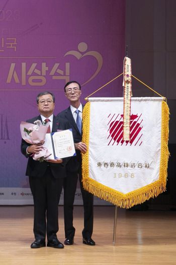 김광수 동서식품 사장(왼쪽)과 최상인 동서식품 홍보상무가 제12회 대한민국 나눔국민대상 대통령 표창을 수상한 뒤 기념촬영하고 있다.[사진제공=동서식품]