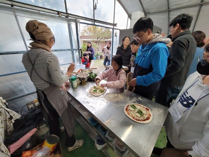 농촌유학생 가족들이 무화과 화덕피자 만들기 체험을 하고 있다. [사진제공=영암군]