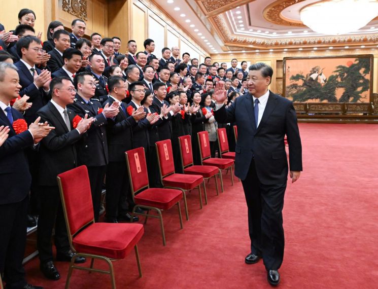 시진핑 중국 국가주석(오른쪽)이 지난 6일 베이징에서 '펑차오(楓橋) 모델'로 선정된 기관·단체 대표들을 만나 인사를 건네고 있다. '펑차오 경험'은 1960년대 저장성 사오싱시 펑차오진에서 도입된 주민 참여형 치안 관리 방식으로, 60년 전 마오쩌둥이 극찬했다. [사진=베이징 신화/연합뉴스]