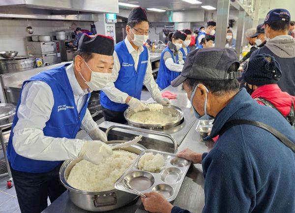 한종희 삼성전자 부회장(왼쪽) 등 삼성전자 임직원들이 지난 6일 경기 성남시 사회복지 기관 '안나의 집'에서 노숙자 대상 배식 봉사에 참여하고 있다. [사진제공=삼성전자]