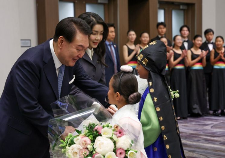 아시아태평양경제협력체(APEC) 정상회의 참석차 미국을 방문한 윤석열 대통령과 부인 김건희 여사가 15일(현지시간) 샌프란시스코 시내 한 호텔에서 열린 동포 오찬 간담회에서 화동으로부터 꽃다발을 받고 있다. [이미지출처=연합뉴스]