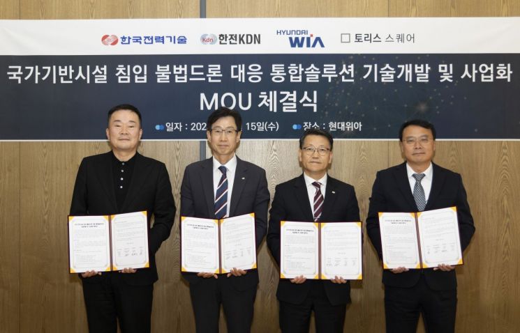 김종수 토리스스퀘어 대표(사진 왼쪽부터), 김용수 한국전력기술 연구원장, 윤흥구 한전KDN 부사장, 이호영 현대위아 상무가 15일 창원 현대위아 본사에서 국가기반시설 침입 불법 드론대응 통합솔루션 기술개발·사업화 협약 체결 후 기념사진을 찍고 있다.[사진제공:현대위아]