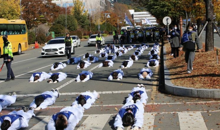 발달장애인 자녀를 둔 경남의 부모들이 아스팔트 위에서 오체투지 행진을 하고 있다. [사진=이세령 기자]