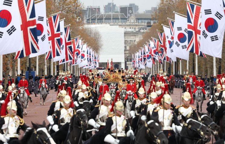 对英国进行国事访问的总统 Yoon Suk Yeol 与英国国王 Charles III 乘坐的马车，在当地时间21日伦敦骑兵卫队阅兵场举行的正式欢迎仪式结束后，正前往白金汉宫。 联合新闻提供