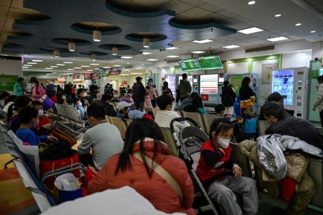24일 중국 베이징에 위치한 한 어린이 병원에서 어린이들과 보호자들이 대기하고 있다. [사진출처=AFP]