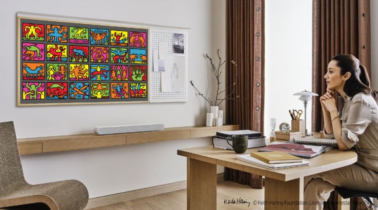 삼성전자 모델이 라이프스타일 TV '더 프레임'을 통해 20세기 아티스트 '키스 해링'의 작품을 감상하고 있다.[사진제공=삼성전자]