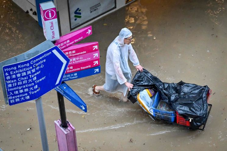 지난 9월8일 홍콩에 기록적인 폭우가 쏟아진 가운데, 한 남성이 짐을 끌고 침수된 거리를 지나고 있다. [이미지출처=연합뉴스]
